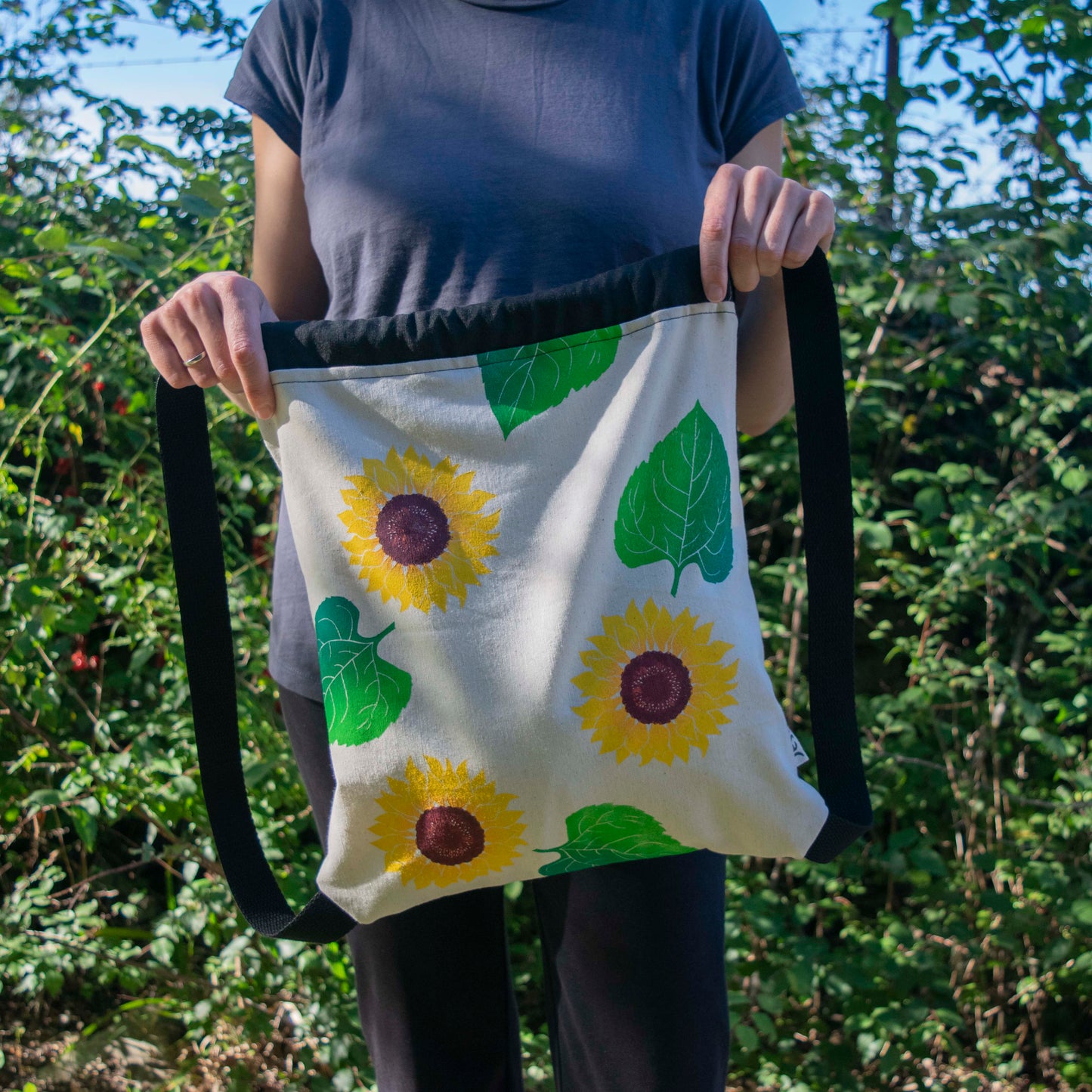 Mochila de loneta, estampada a mano, cosida a mano. Estampado de girasoles, inspirada en la naturaleza. Complemento textil ilustrado. Materiales sostenibles, telas recuperadas.