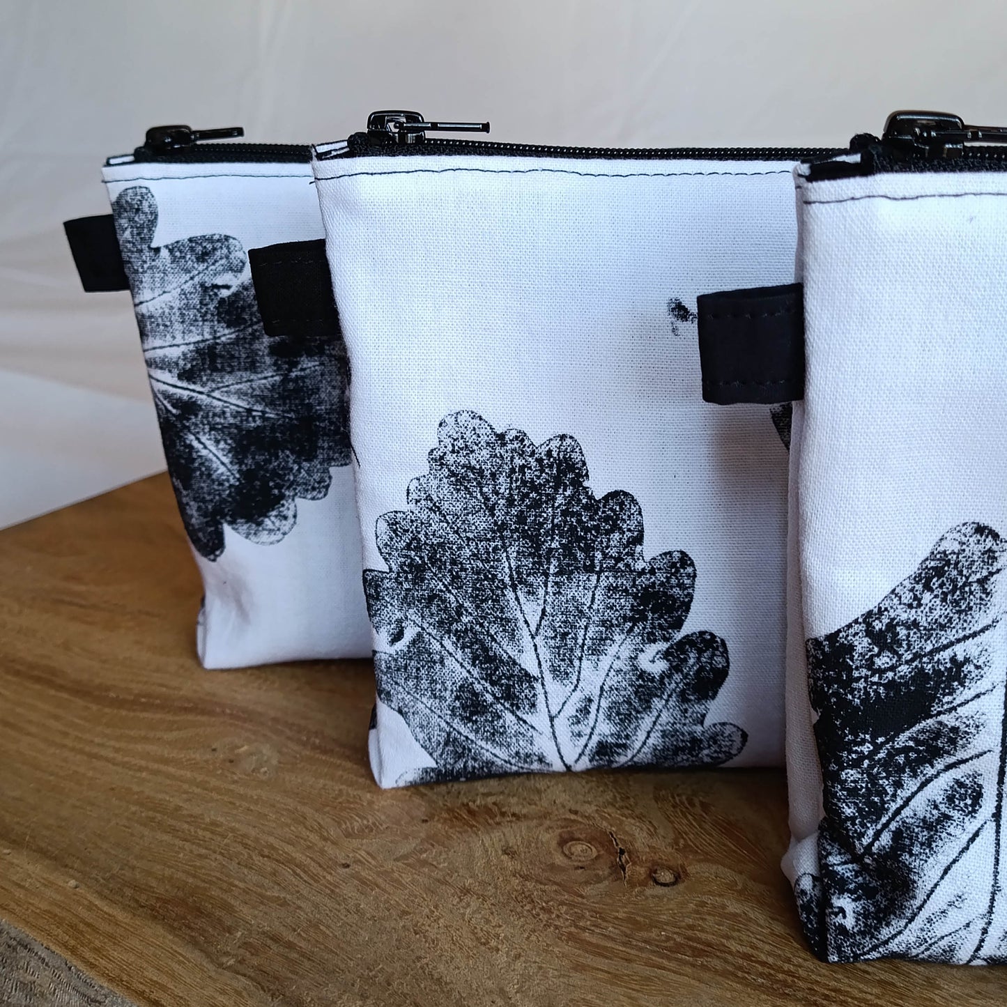 Neceser sostenible, hecho con tela recuperada. Estampado con hojas de roble. Detalle de la tela estampada. Cosido a mano.