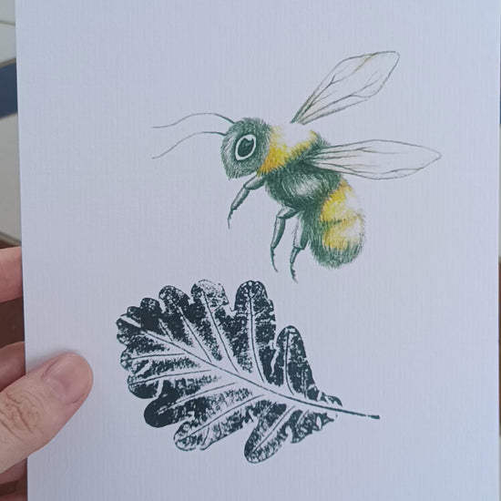 Lámina de abeja ilustrada y hoja de roble estampada con tinta negra.